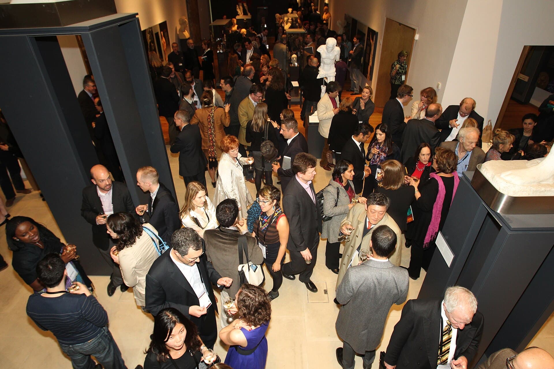 Investors and founders in conversation at a crowded evening reception